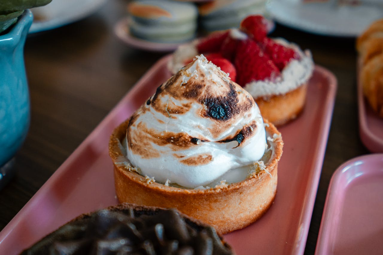 about-us-02 Close-up of assorted pastries on pink platters, perfect for brunch or dessert.